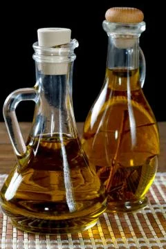 Two bottles of olive oil on rustic table Stock Photos