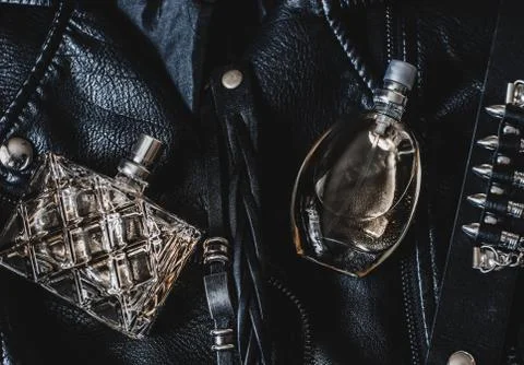 Two bottles of perfume for women on a black leather jacket Stock Photos