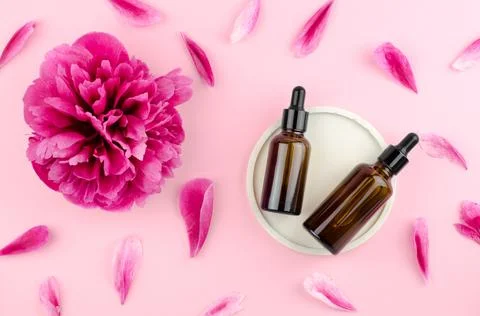 Two bottles of serum or essential oil on a pink background Stock Photos