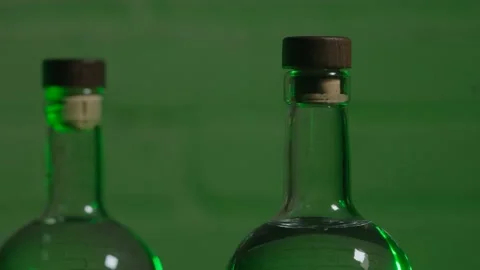 Two bottles of vodka against a white brick wall Stock Footage 185189937
