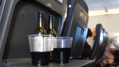 Two bottles of wine and glasses on aircraft tray table Vidéo 106950370