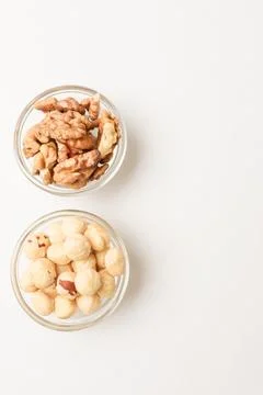 Two bowls with hazelnuts and walnuts on white background. Copy space Stock Photos