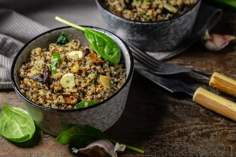 Two bowls with quinoa, mushrooms, garlic and spinach Stock Photos