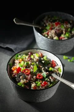 Two bowls with quinoa, paprika, beans and olives Stock Photos