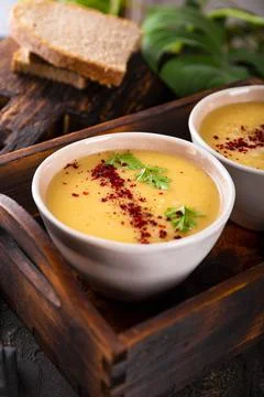 Two bowls of split pea puree soup on dark background close up vertical photo Stock Photos