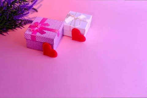 Two boxes of blue and pink in the foreground are tied with satin ribbons.Wild Stock Photos