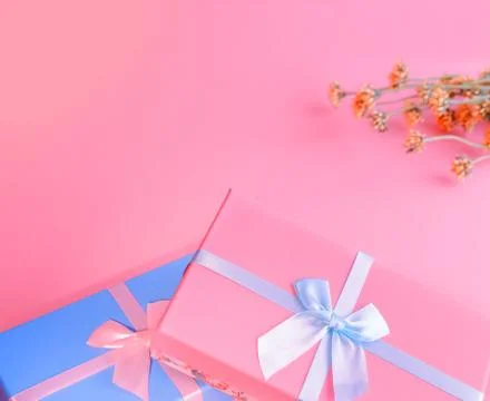 Two boxes of blue and pink in the foreground are tied with satin ribbons. Wil Stock Photos