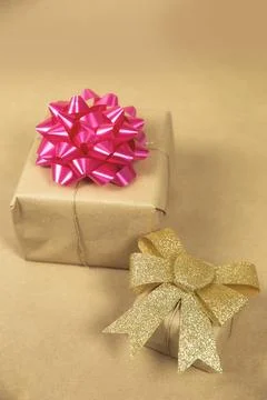 Two boxes in eco brown plain paper witg gold and pink wrapping decoration Stock Photos