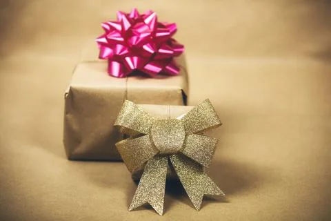 Two boxes in eco brown plain paper with gold and pink wrapping decoration Stock Photos