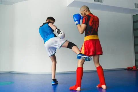 Two boxing men exercising together at the health club Stock Photos