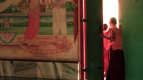Two boy monks Exit Through The Door Of A Buddhist temple. Stock Footage 39786697