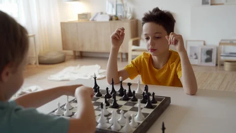 Two boy playing chess in light room. Two brothers playing chess. Stock Footage 105090579