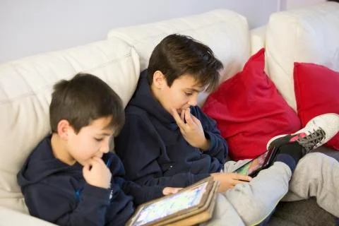 Two boy playing with their tablets Stock Photos