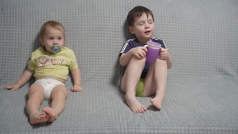 Two boy watching something on television and sitting on sofa. Stock Footage 302094566