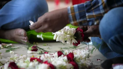 Two boys are making garlands of different flowers Stock Footage 151680440