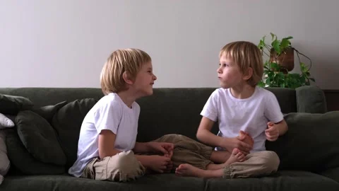 Two boys are playing on the couch, and one of them is tickling the other Stock Footage 321406801