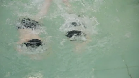 Two boys are swimming in the pool. Swimming in the school pool. Guys learn to Video stock 117181757