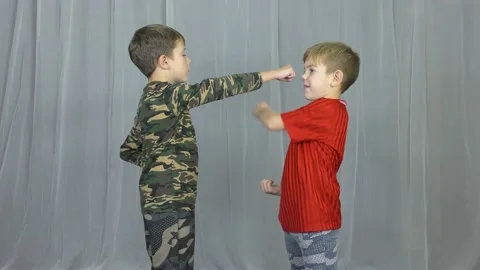 Two boys athlete perform blocks and punches on a light background Video stock 141545165