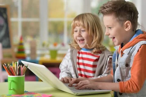 Two boys at class using laptop and writing Stock Photos