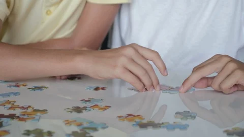 Two boys collect puzzles. Teamwork. Way to success. Happy family is engaged in Video stock 121529074