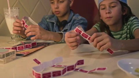 Two Boys Counting Game Coupons before Playing on Arcade Machines Stock Footage 299731042