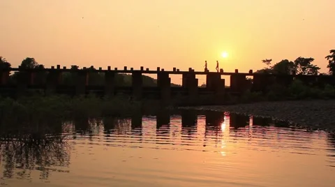 Two boys crossing the bridge during sunset in Rural India. Stockbeeldmateriaal 55433068