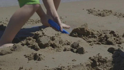 Two Boys Digging in the Sand at Beach Stock Footage 74383377
