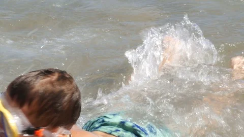 Two boys in diving mask having fun in sea waves - 4K Stock Footage 80232739