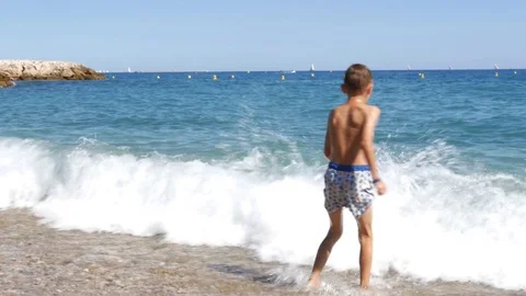 Two boys in diving mask splashing in sea waves - 4K Stock Footage 80232333