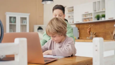 Two boys do homework. Older brother helps the younger one with homework Young Stock Footage 139257773