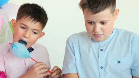Two boys eats cotton candies at birthday party Видео 138071653