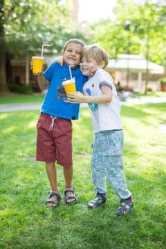 Two boys hugging one another or fighting jokingly while drinking cocoa outdoo Foto stock