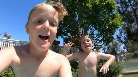 Two Boys Jump Into Pool Together Stockbeeldmateriaal 129782624