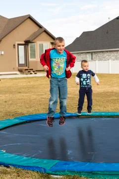 Two Boys Jumping On Trampoline Stock Photos