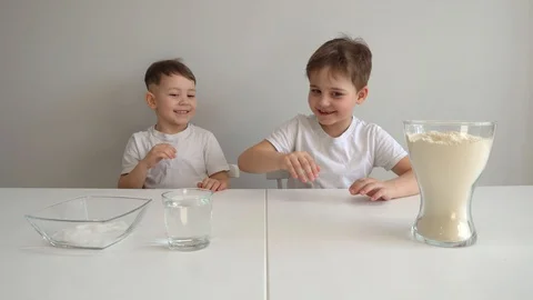 Two boys make dough in the kitchen Video stock 128825845