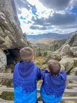 Two boys in the mountains looking at the cloudy sky Stock Photos