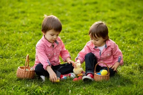 Two boys in the park, having fun with colored eggs for Easter Stock Photos
