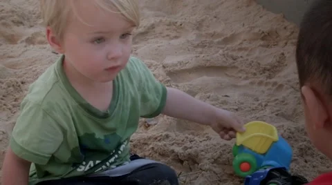 Two boys playing in a sandpit Stock Footage 59132124