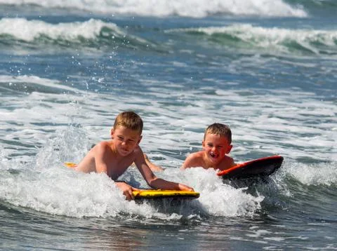 Two boys playing in surf Stock-Fotos