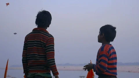 Two boys playing their kites on the Ghats along the Holy River. Varanasi. Stock Footage 107847361