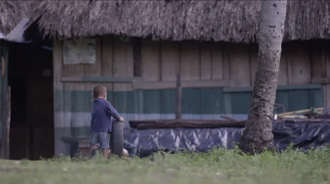 Two boys playing with tire outside a hut in village, Guatemala Stock Footage 63053845
