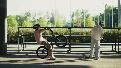 Two Boys Practicing BMX Bicycle and Scooter Stunts in Skate Park Video stock 346146852