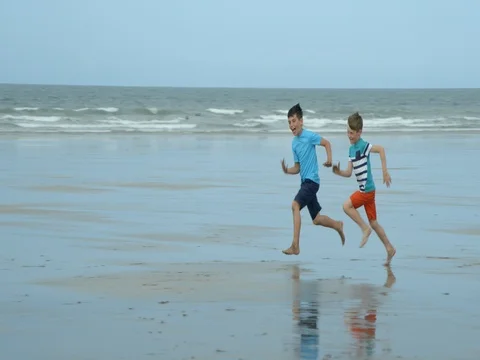 Two Boys Racing on the beach and having fun. Vídeo Stock 79793641