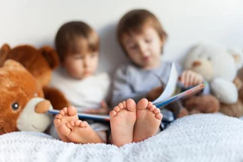 Two boys, reading a book, educating themselves Stock Photos