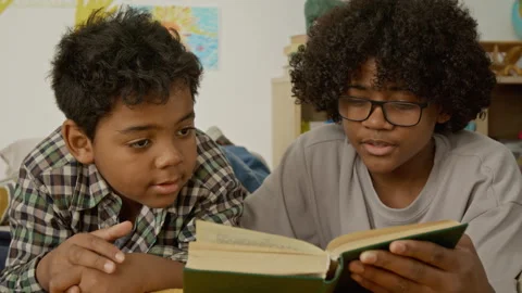 Two Boys Reading Book Together for Education and Learning Stock Footage 342499641
