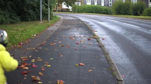 Two boys  riding bicycles on the wet pavement Stock Footage 80921567