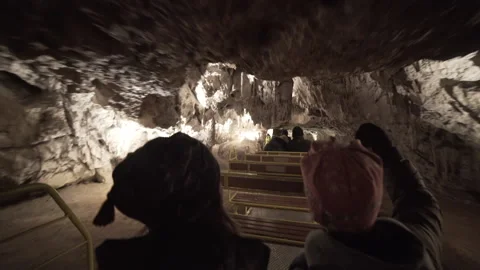 Two boys riding through Postojna cave and stalactites Video stock 134507237