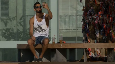 Two Boys Sitting On a Bench Take a Selfie, Tel Aviv, Israel Stock Footage 90382807