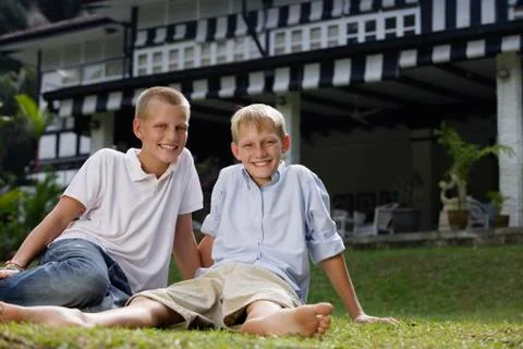Two boys sitting on grass Stock Photos