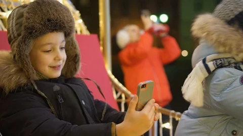 Two boys take selfie on the square near the Christmas tree Video stock 94047205